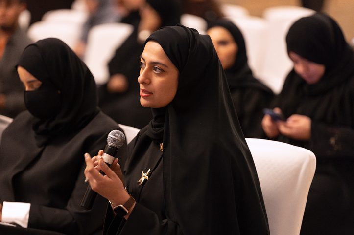 A participant asking a question with a microphone during an Ibtechar session